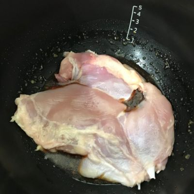 内鍋に加熱前の鶏もも肉と調味料が入っている写真