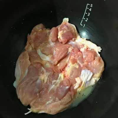 調味料を入れた内鍋に皮目を下にして鶏もも肉を入れている写真