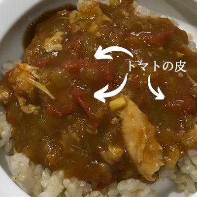 カレーの中に赤いものがあり、「トマトの皮」と矢印で刺されている画像